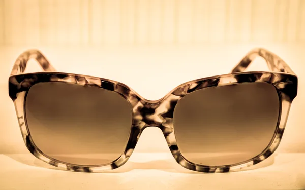 Optical frames arranged on backlit shelving